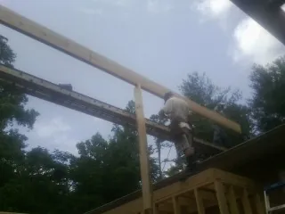 Carpenter setting a ridge beam over a new addition frame in Rio Linda