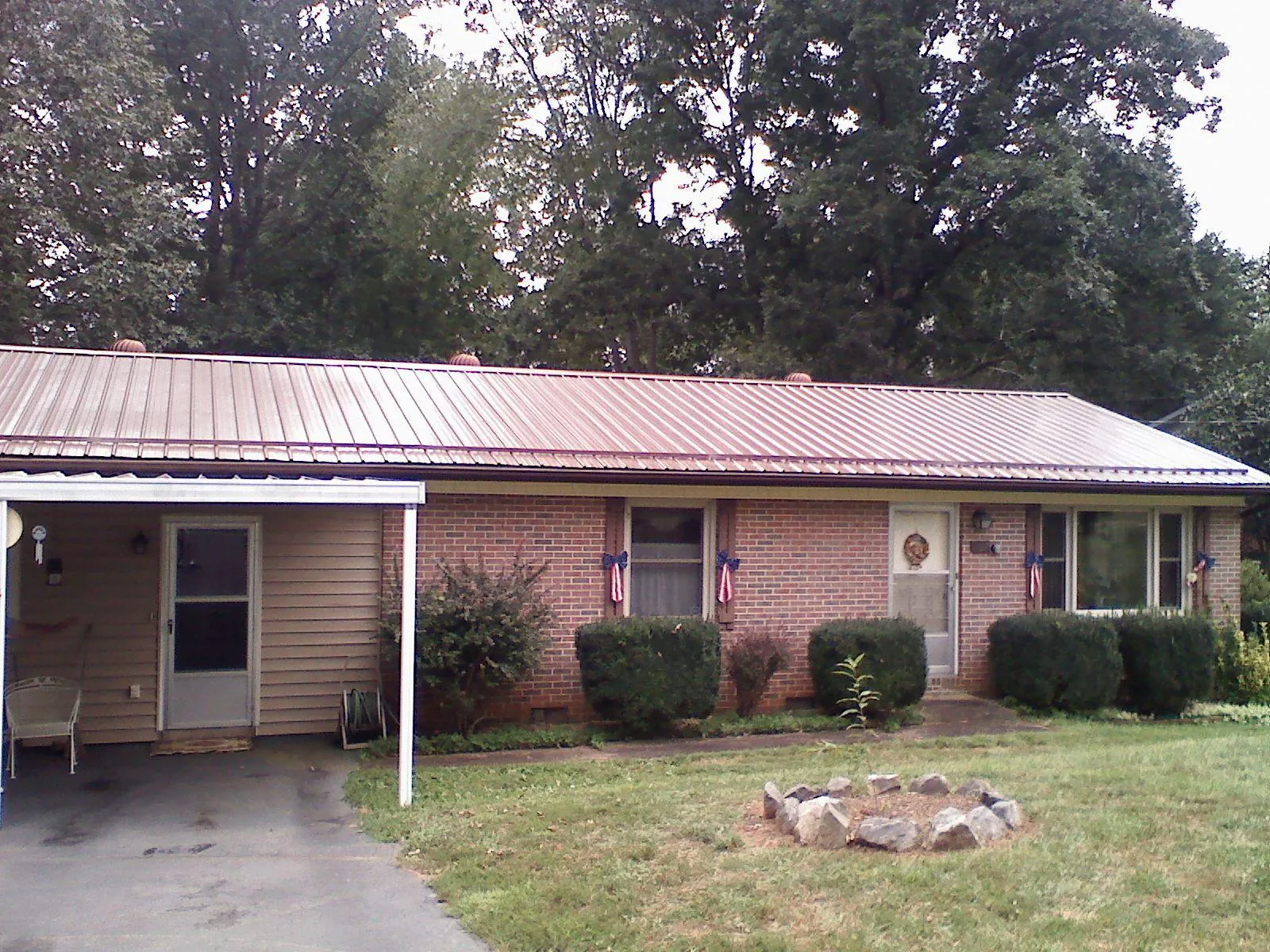Bronze metal roof and carport on a brick ranch home — Roof Repair work by our crew in Rio Linda